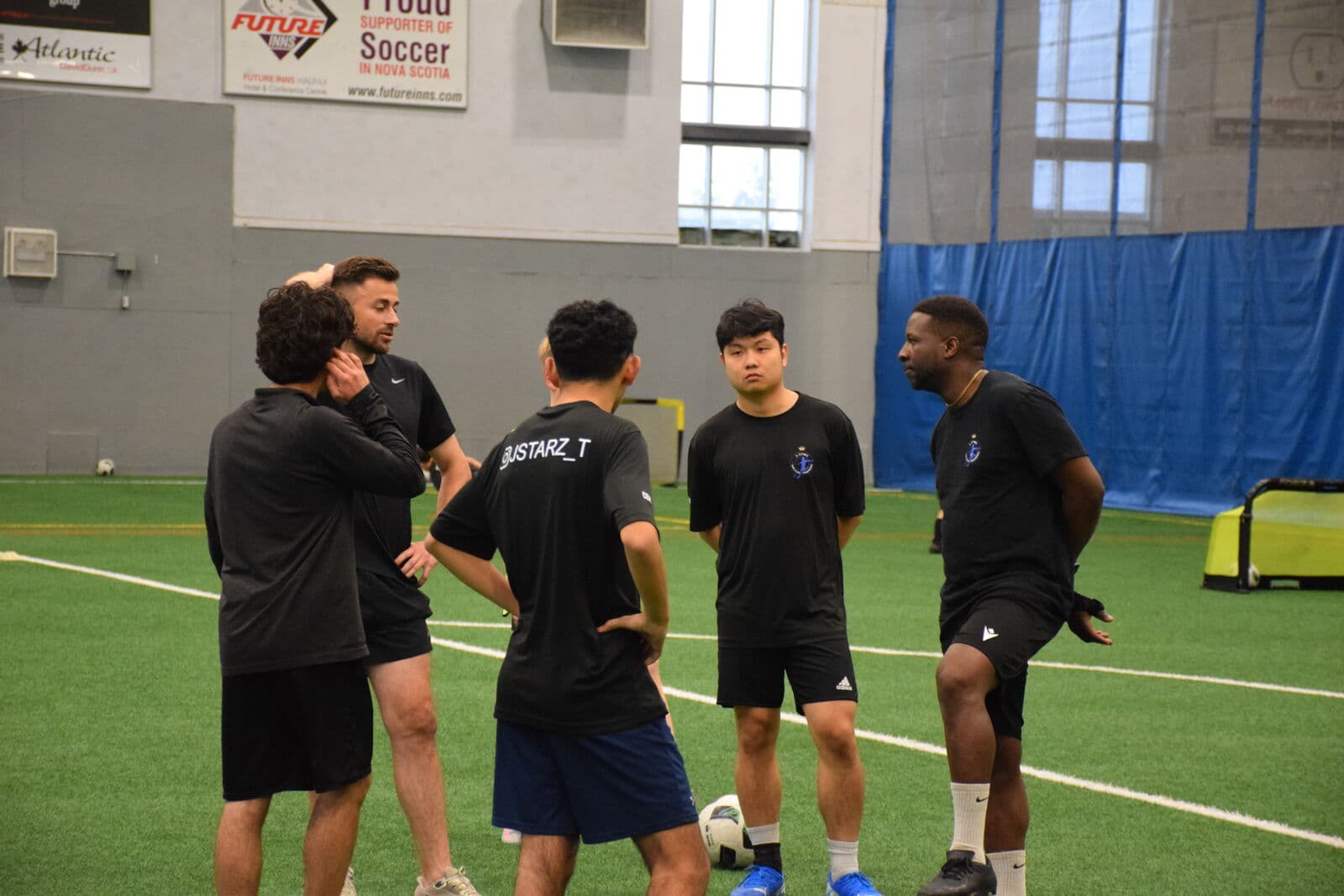 Young players gathered around their coach during a training break.